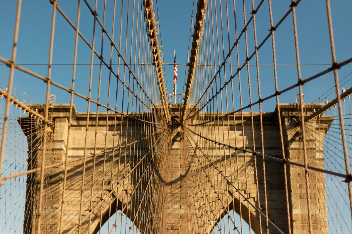 Looking up at a Gothic Revival tower and the cables of the Brooklyn Bridge, a stop on a New York architecture tour