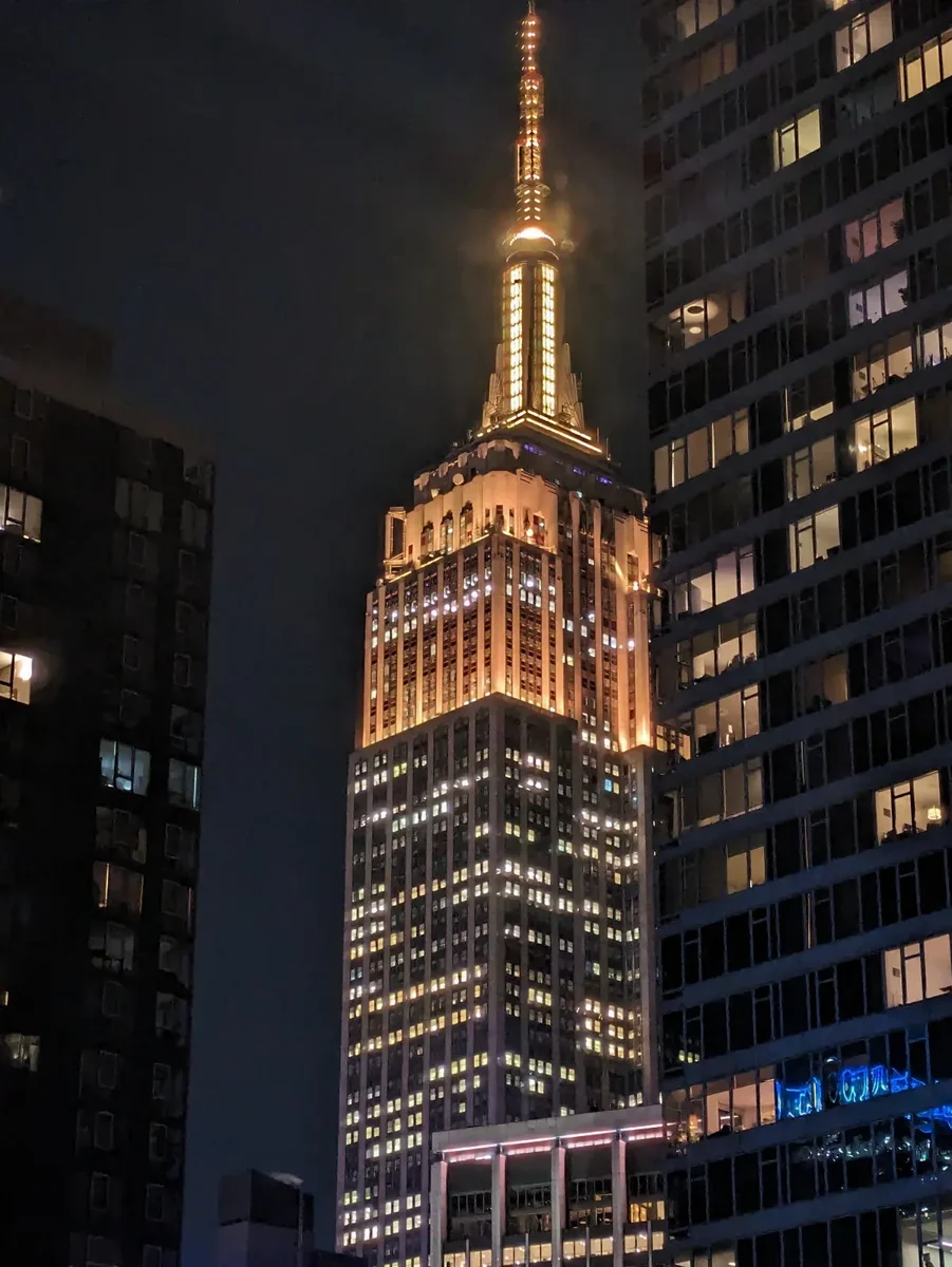 The Empire State Building lit at night above Midtown, a stop on a New York architecture tour