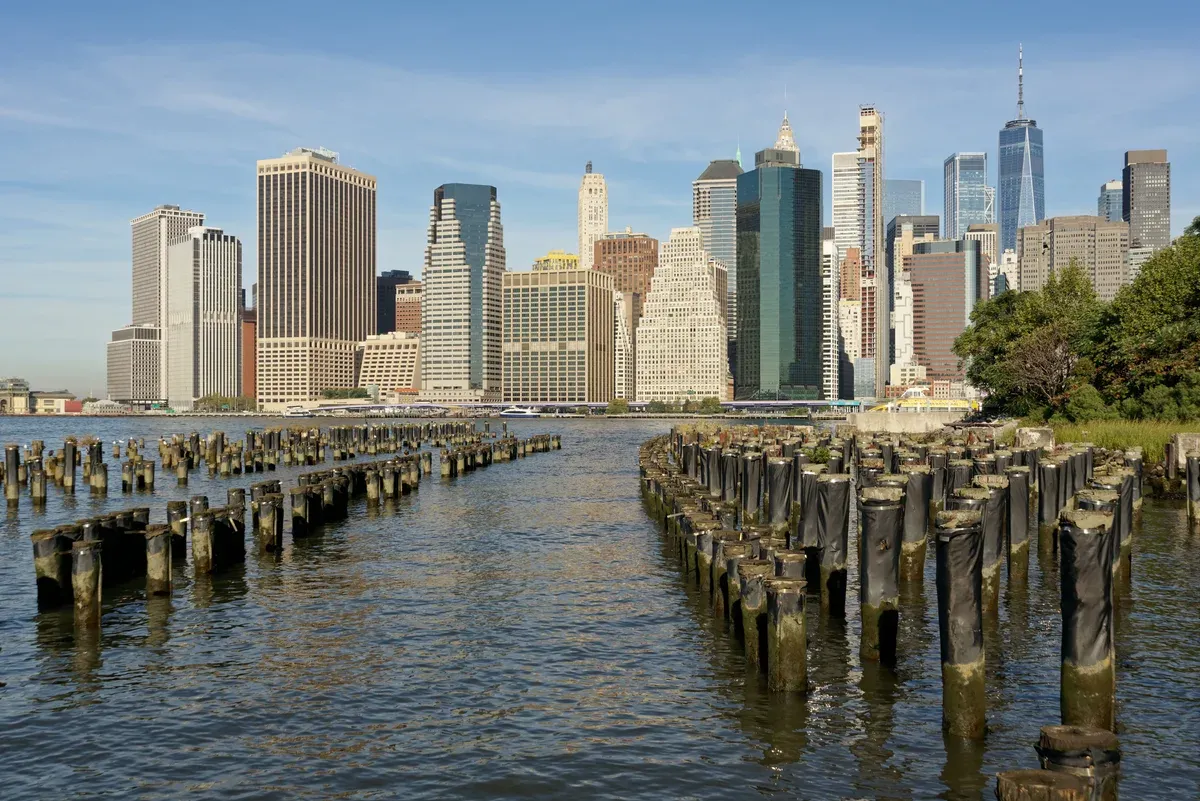 The Lower Manhattan skyline across old wooden piers at Brooklyn Bridge Park, on a New York architecture tour