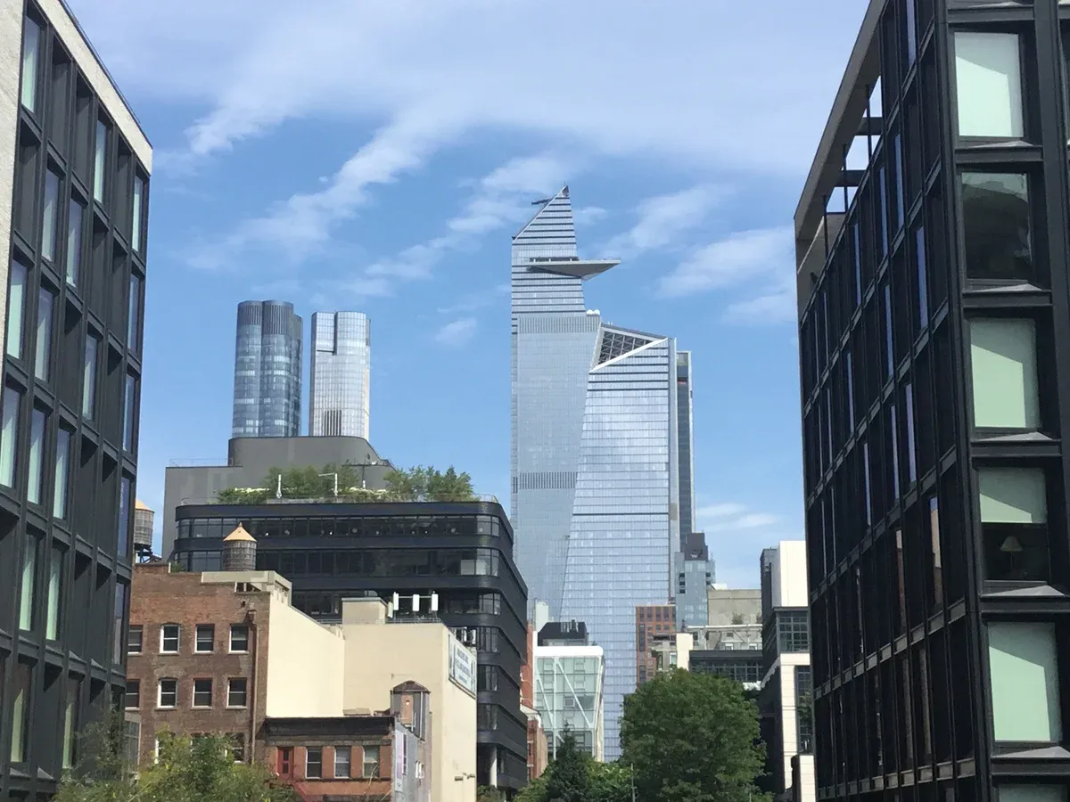Hudson Yards towers rising between buildings along the High Line, on a New York architecture tour
