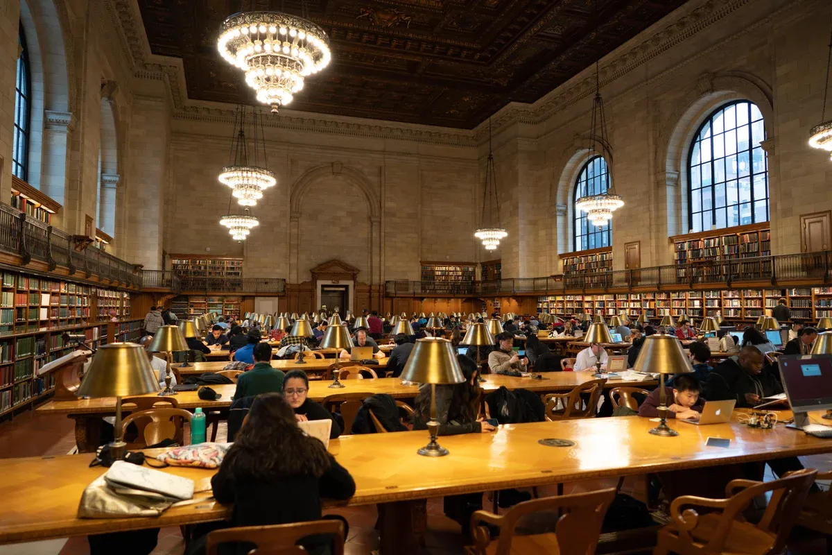Long reading tables and brass lamps in the Rose Main Reading Room of the New York Public Library, on a New York architecture tour